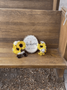 Sign and sunflowers reserving a seat for family members that are in heaven at a wedding ceremony at All4One Farms in Jacksonville, FL.